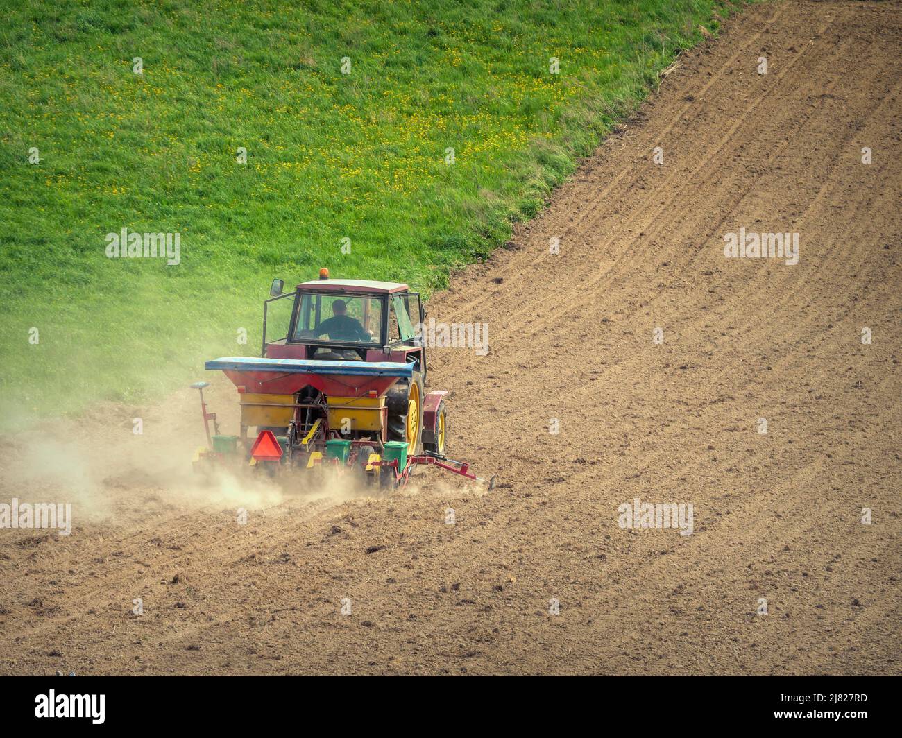 Campo arabile piantato da trattore agricolo con seminatrice Foto Stock