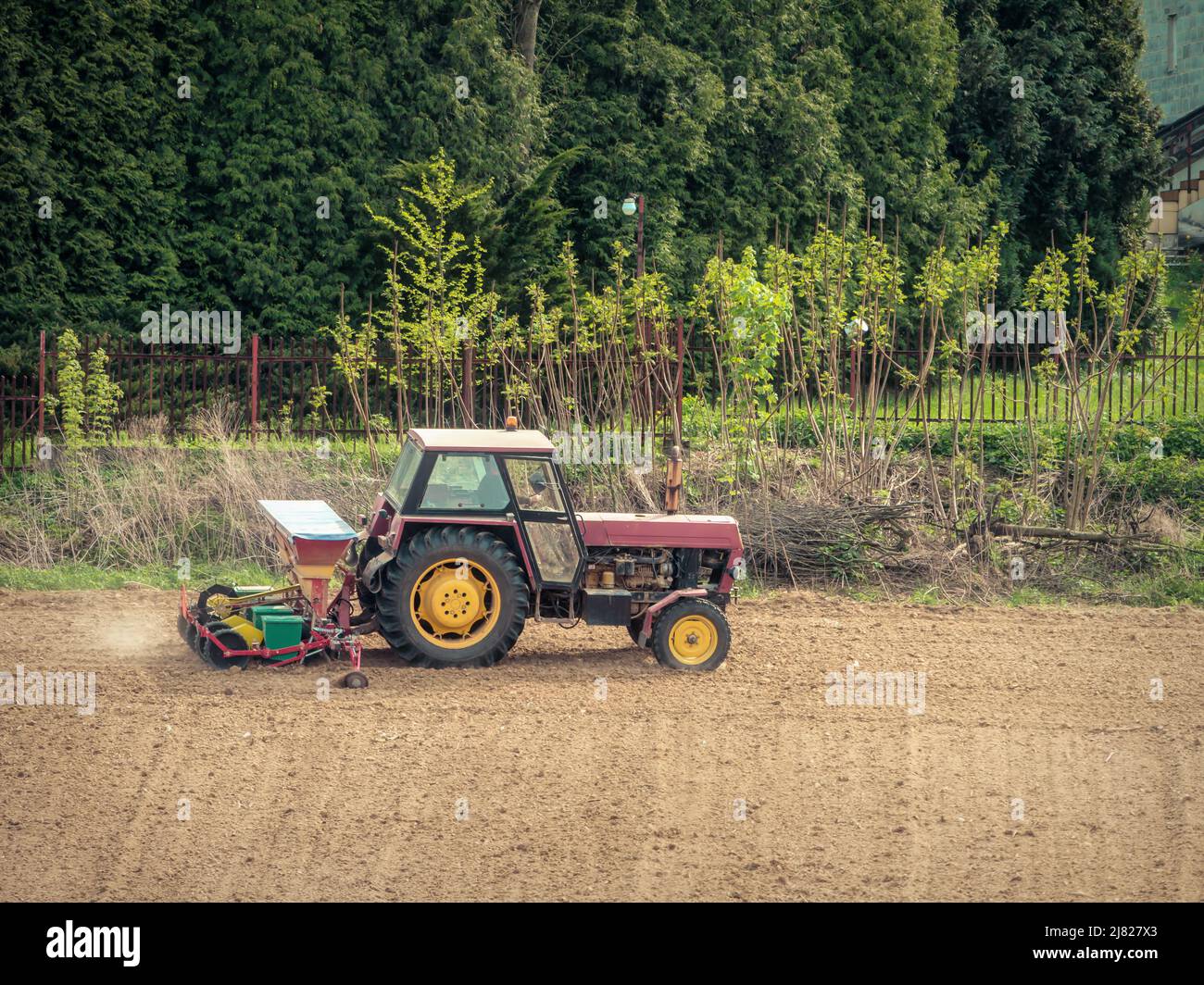 Campo arabile piantato da trattore agricolo con seminatrice Foto Stock