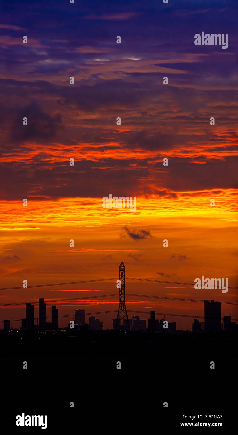 Tramonto sulla città con le silhouette nere degli edifici Foto Stock