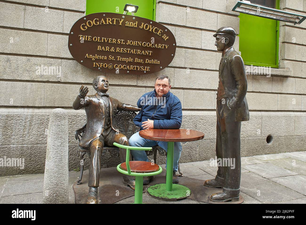 Statue di bronzo di Oliver Saint John Gogarty e James Joyce fuori dal pub con lo stesso nome a Temple Bar Dublino, Irlanda con uomo turistico Foto Stock