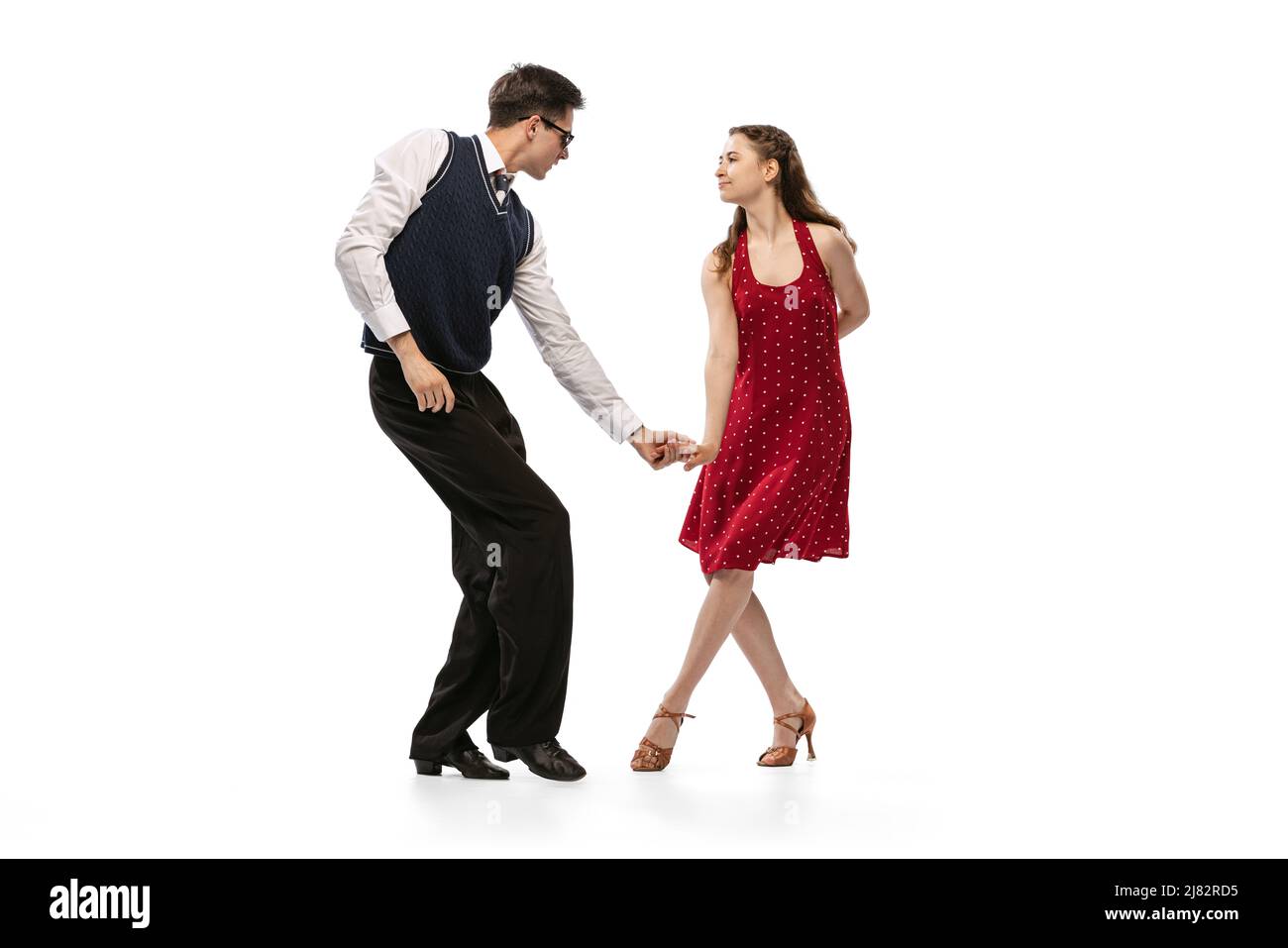 Bella ragazza e uomo elegante in vintage stile retrò abiti ballare isolato su sfondo bianco. Tradizioni senza tempo, 60s,70s moda americana Foto Stock