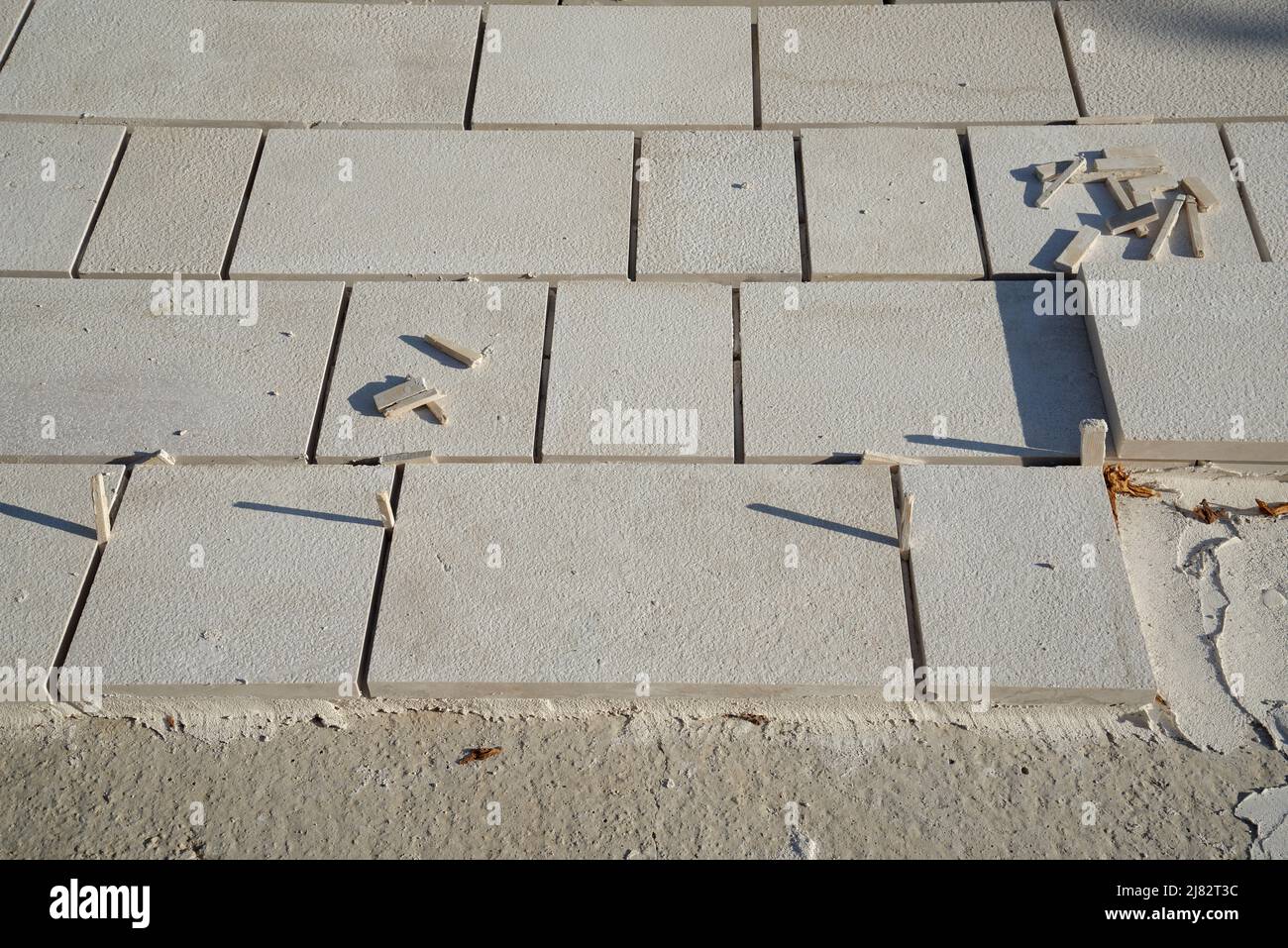 Posa di lastre di pavimentazione. Lasciare uno spazio tra ciascuno di essi per riempire con una Malta o un riempitivo di cemento. Lavori in corso. Foto Stock
