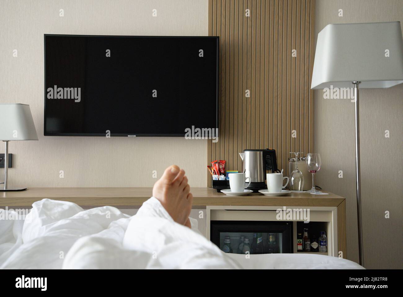 Camera in stile hotel senza descrizione con set per la preparazione di tè e caffè, TV e minibar-frigorifero. Foto Stock