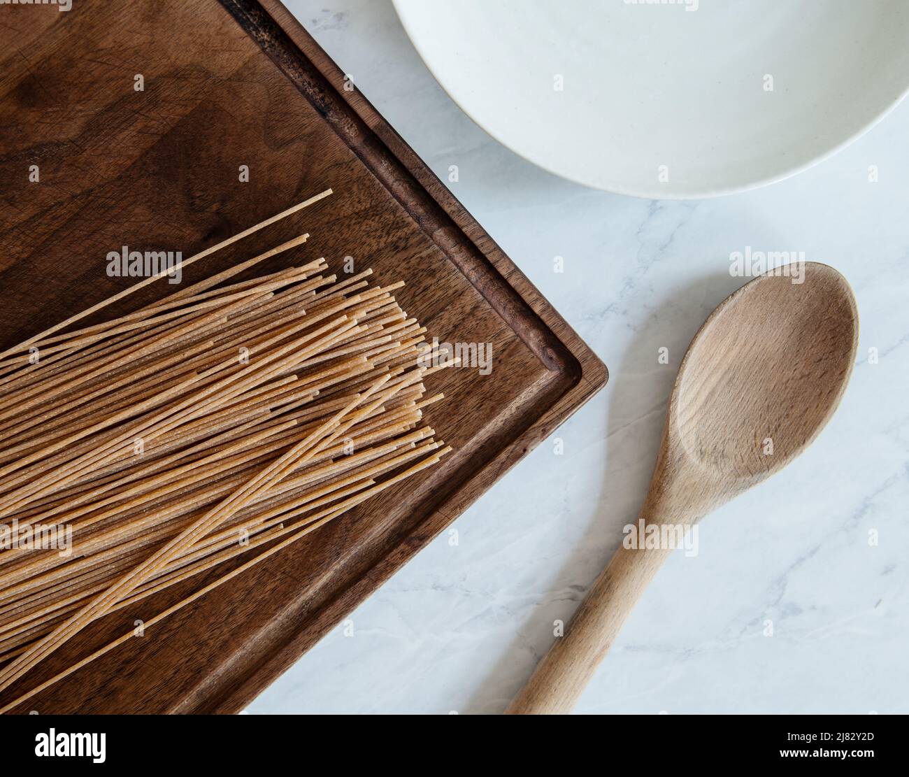 Asciugare la pasta di grano intero con un cucchiaio di legno Foto Stock