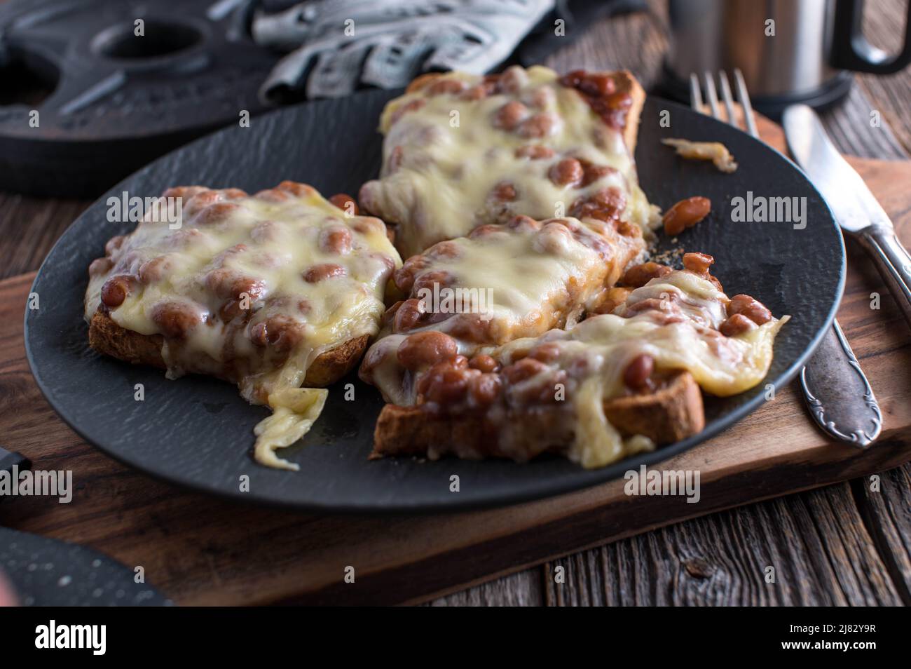 Pasto fitness per la costruzione muscolare con un toast intero di grano con fagioli cotti e formaggio leggero su un piatto Foto Stock