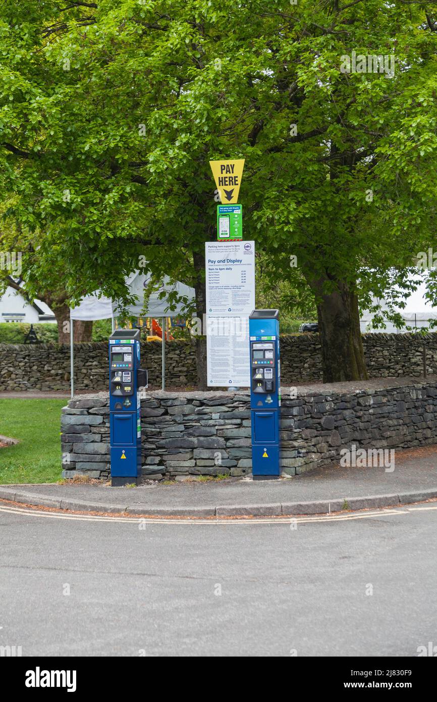 Parchimetri e cartelli a pagamento nel parcheggio di Grasmere nel Lake District, Inghilterra, Regno Unito Foto Stock