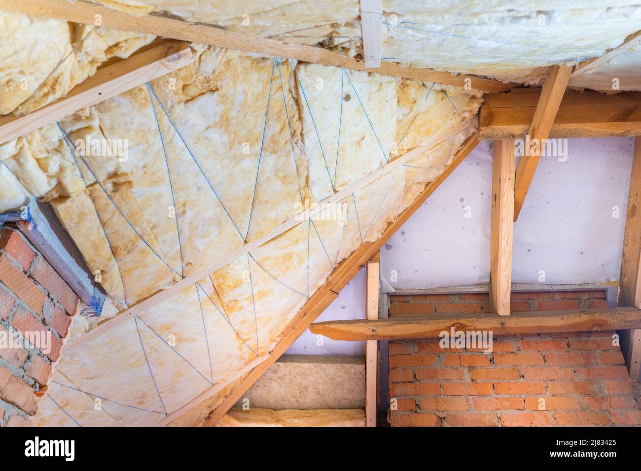 Il tetto è isolato con lana di vetro gialla. Isolamento del tetto corretto. Foto prima e dopo l'isolamento del tetto Foto Stock