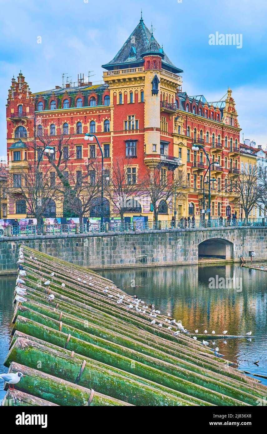 Il bel palazzo rosso Bellevue visto dietro la barriera di legno sul fiume Moldava, Praga, Repubblica Ceca Foto Stock