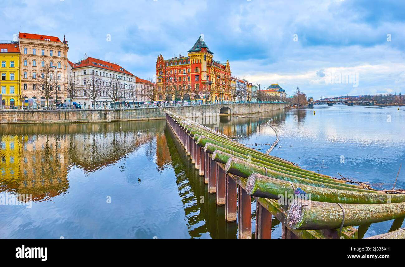 Panorama della superficie del fiume Moldava specchio con rompighiaccio in legno e Bellevue mansione rossa su Smetana Embankment sullo sfondo, Praga, Repubblica Ceca Foto Stock