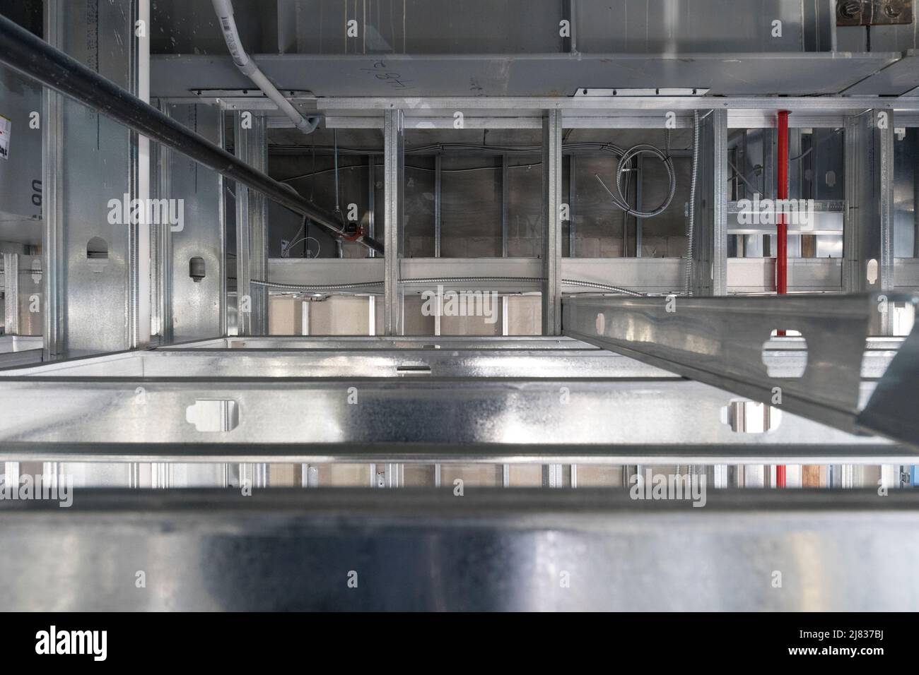 Vista dello spazio strutturale sopra il soffitto a discesa in un edificio commerciale Foto Stock