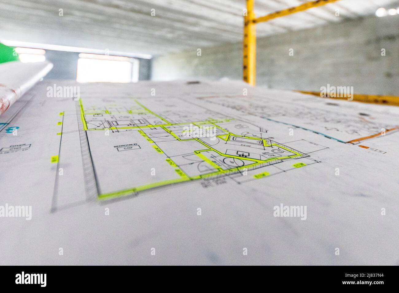 Blueprint con evidenziatore giallo o marcatore posto su un tavolo angolato Foto Stock