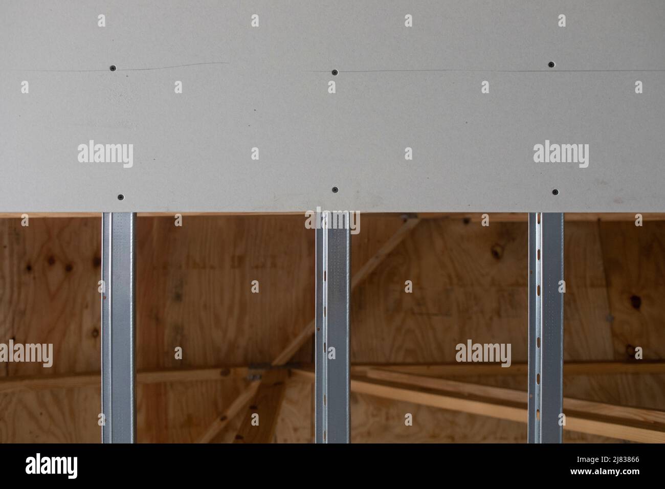 Soffitto a soffitto con installazione a soffitto a secco o in pietra con guide in acciaio zincato per l'installazione della lamiera successiva Foto Stock