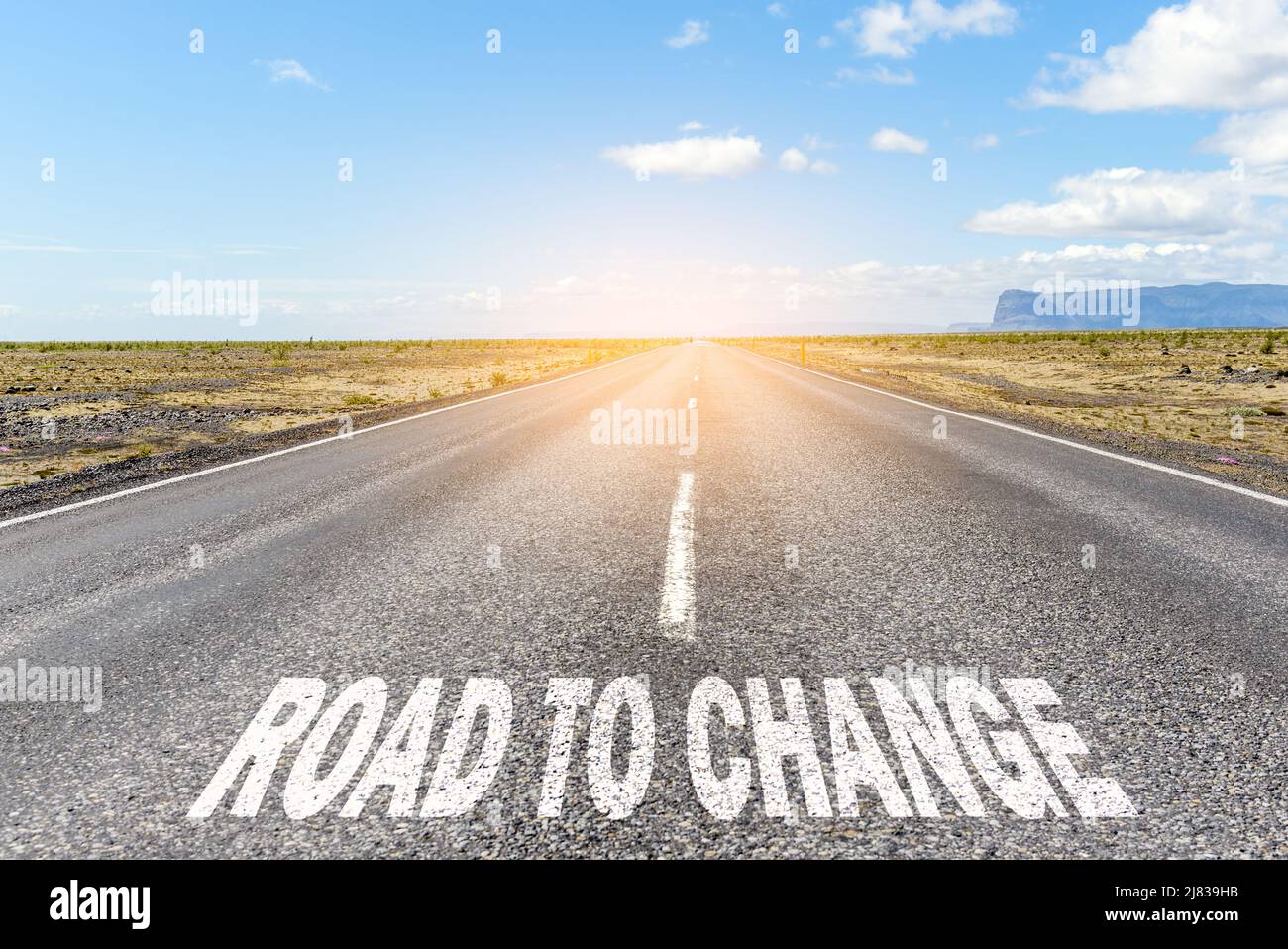 Strada per cambiare. Immagine concettuale di una strada retta deserta attraverso un paesaggio desertico con il testo "strada al cambiamento" scritto su asfalto Foto Stock