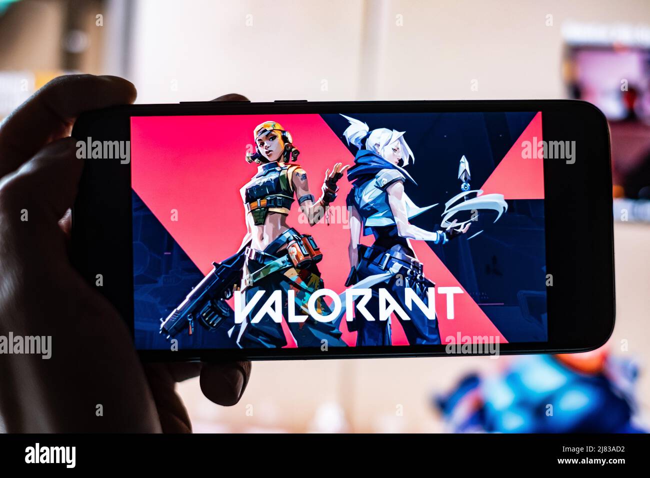 Valorant Game Title è mostrato sullo schermo del telefono cellulare con Twitch Streamer gioco in background. Un gioco realizzato da Riot Games a Los Angeles. Foto Stock