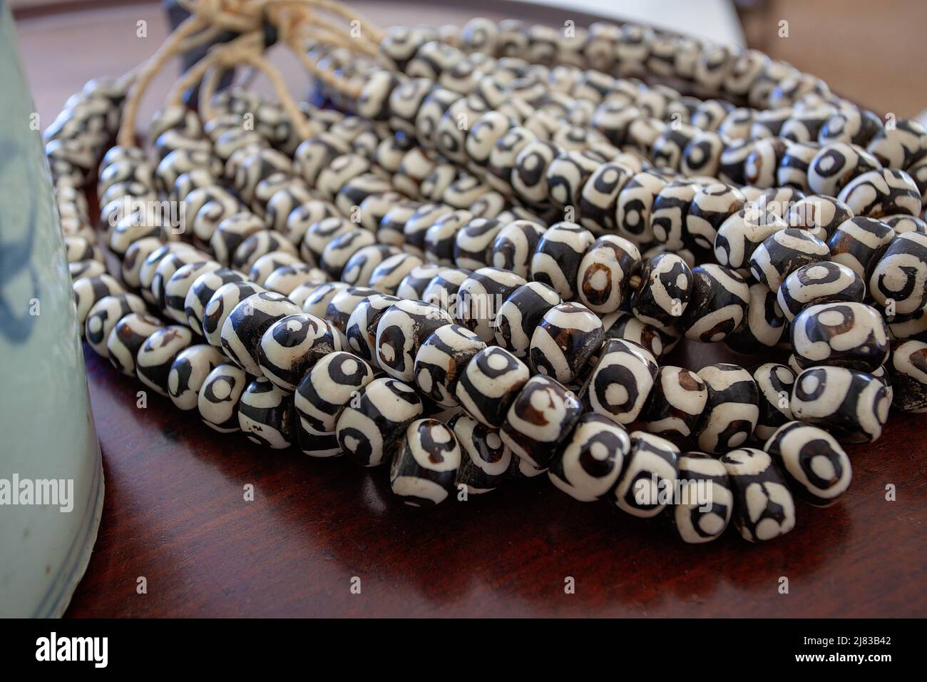 Contrasto naturale: Perline in ceramica su corda di canapa Foto Stock