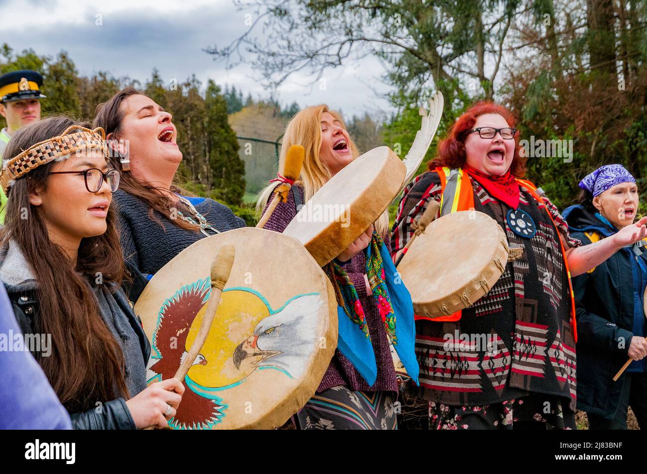 Le donne indigene tamburo e cantare al Kinder Morgan blocco di pipeline, Montagna Burnaby, British Columbia, Canada. Foto Stock