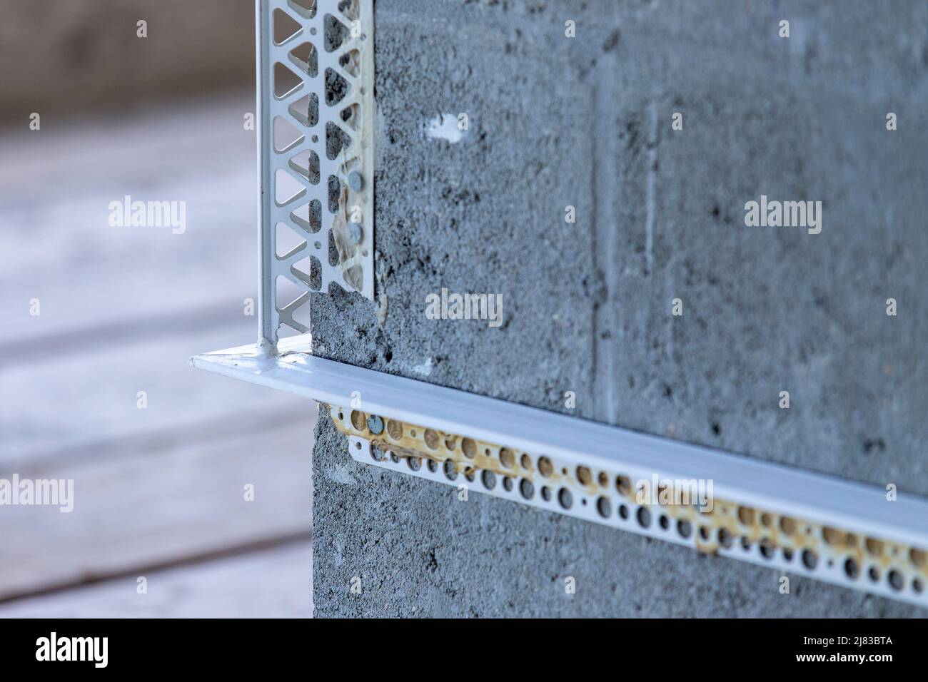Angolo dell'edificio in costruzione che mostra blocchi di cemento con bordatura angolare su di esso per l'installazione di Stucco Foto Stock