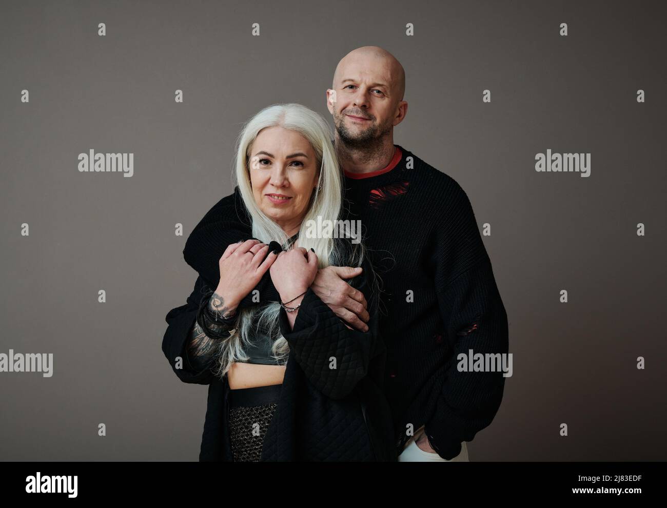 Primo piano orizzontale medio di bell'uomo caucasico maturo e donna attraente in amore indossando abiti alla moda guardando la macchina fotografica Foto Stock