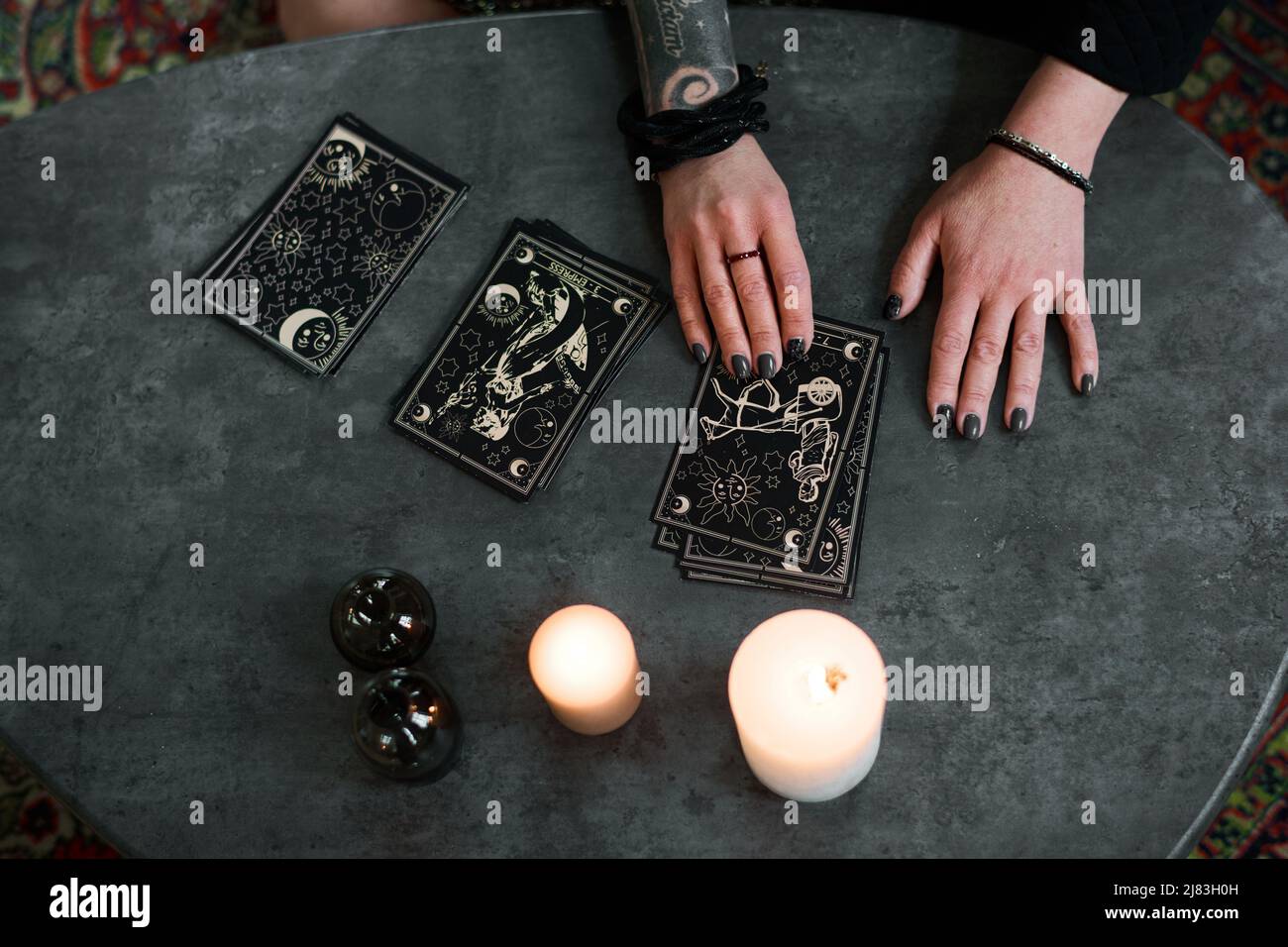 Da sopra vista scatto di misteriosa donna matura interessata a esoterismo impostazione e lettura carte tarocchi Foto Stock