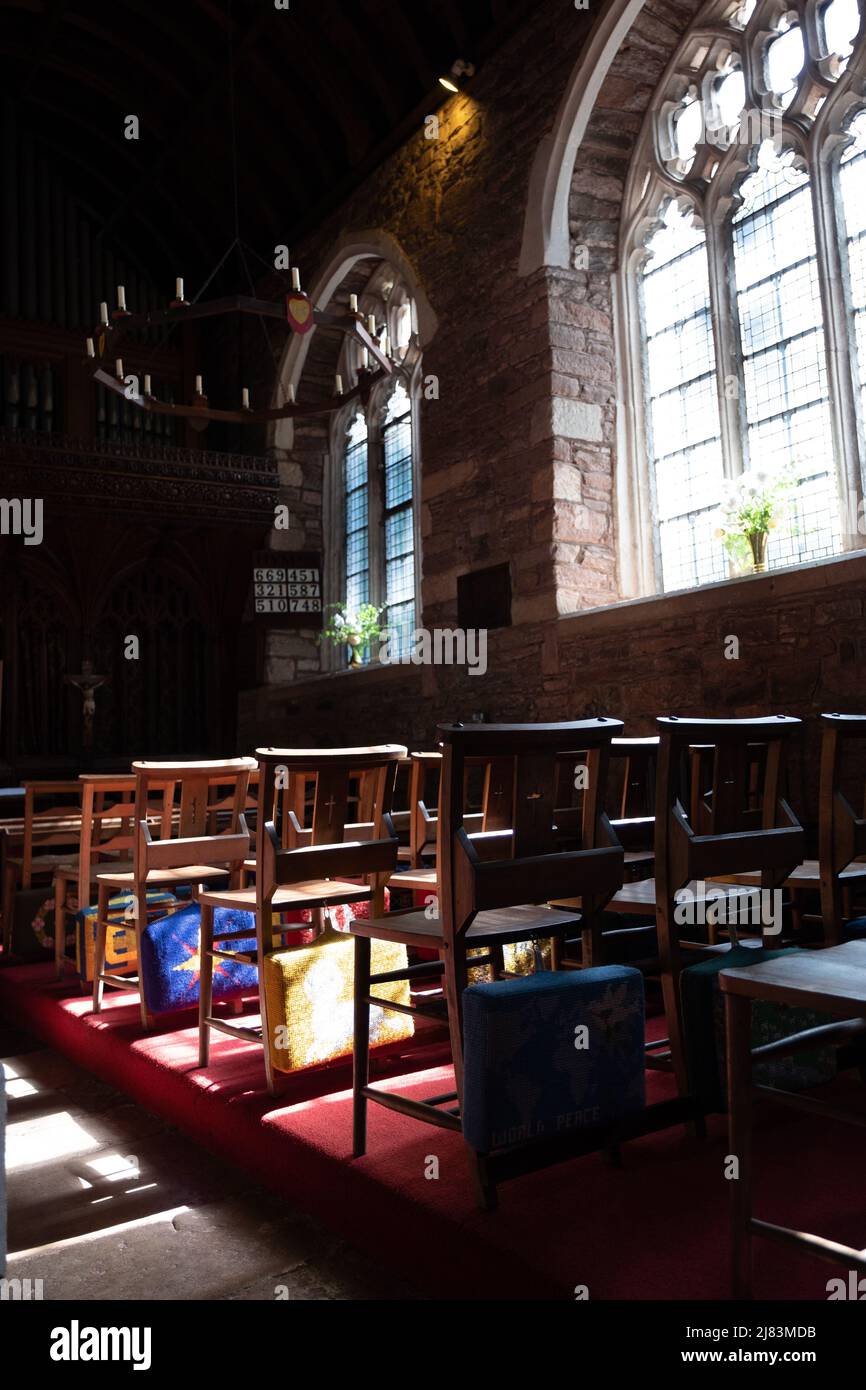 Cuscini ricamati di preghiera sul retro di sedie di legno nella Cockington Court Church, Devon. Foto Stock