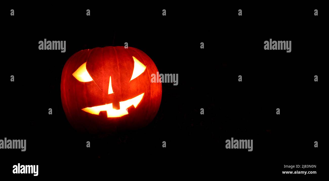 Zucche incandescenti di notte, faccia della zucca, zucche intagliate, grimace, Halloween, sfondo scuro Foto Stock