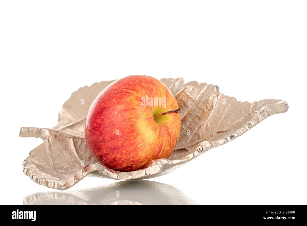 Una mela biologica matura con un vaso metallico, primo piano, isolato su sfondo bianco. Foto Stock