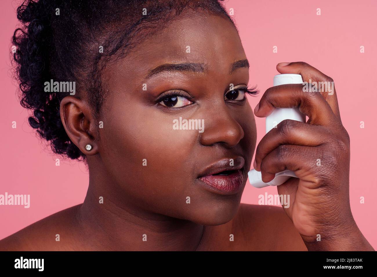 Donna afroamericana su sfondo rosa isolato sensazione di malessere e tosse come sintomo di raffreddore o bronchite Foto Stock