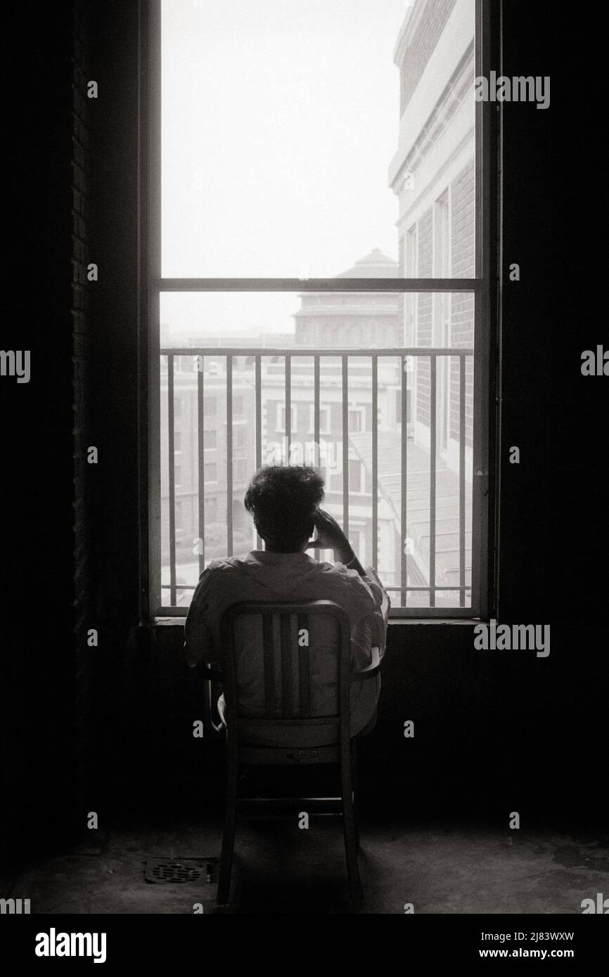 1970S DONNA ANONIMA SEDUTA GIÙ SAD DEPRESSO IN SCURO APPARTAMENTO SILHOUETTED IN CORNICE FINESTRA CON FUOCO FUGA PRIGIONE COME BAR - S18985 HAR001 HARS ANSIA SOGNI ALTO ANGOLO SILHOUETTED DISPERAZIONE ISTITUZIONE UMORE SALUTE MENTALE GLUM CONCETTUALE CITTÀ FUGA OSPEDALI SOLITUDINE STRUTTURA ANONYMOUS STRUTTURE TENSIONE IDEE MISERABILE IN BIANCO E NERO HAR001 MALATTIA MENTALE VECCHIO STILE Foto Stock