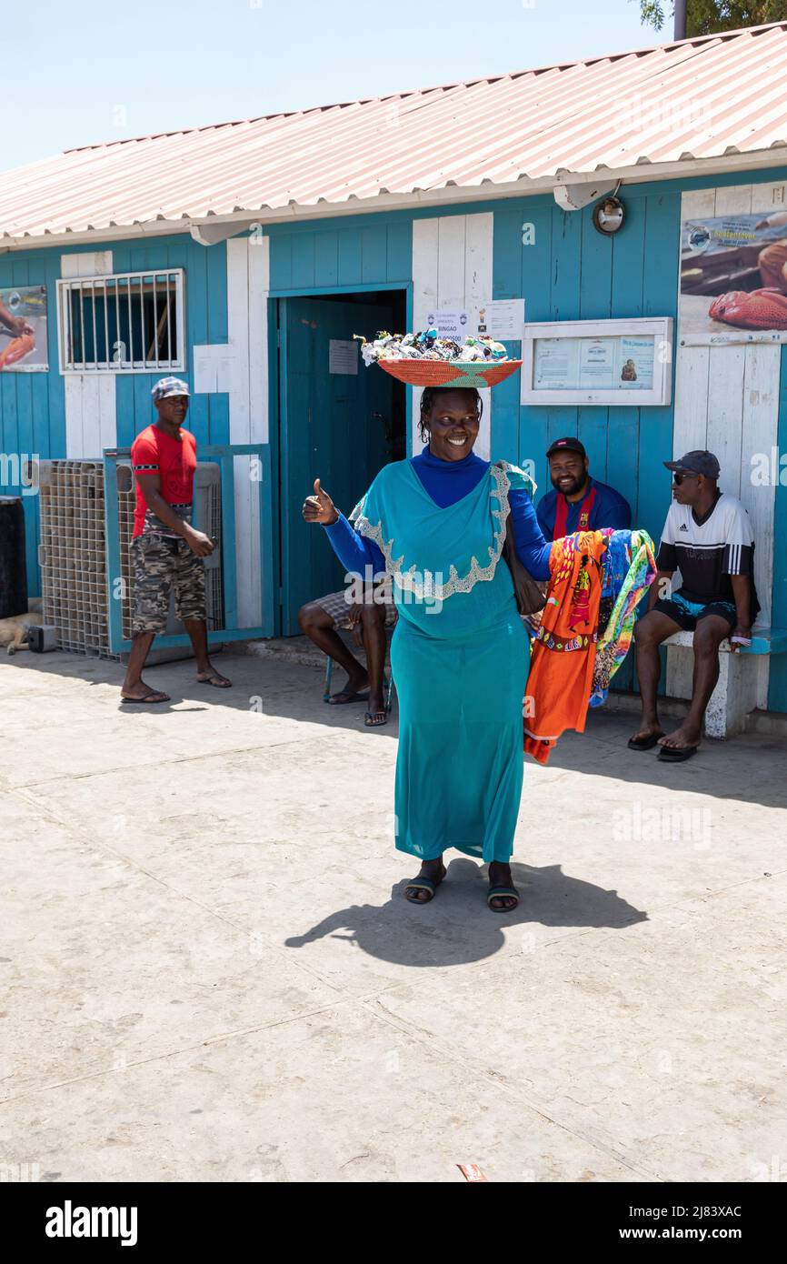 Le donne locali felici che portano un cestino di souvenir tradizionali sulla sua testa vendere ai turisti. Palmeira, SAL, Capo Verde, Isole Cabo Verde, Africa Foto Stock