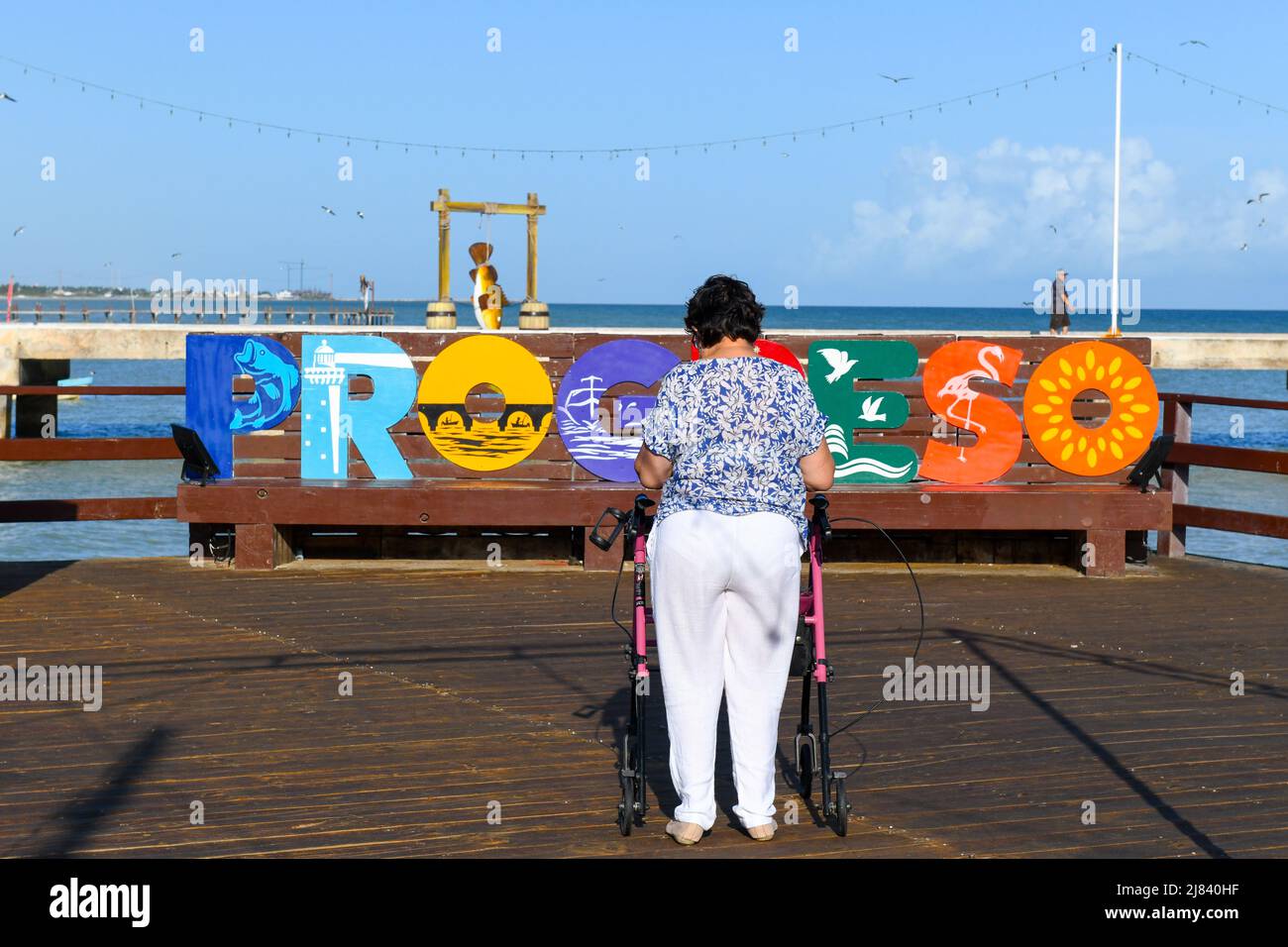 Donna cammina sul lungomare con l'aiuto di un camminatore , Progreso , Yucatan, Messico Foto Stock