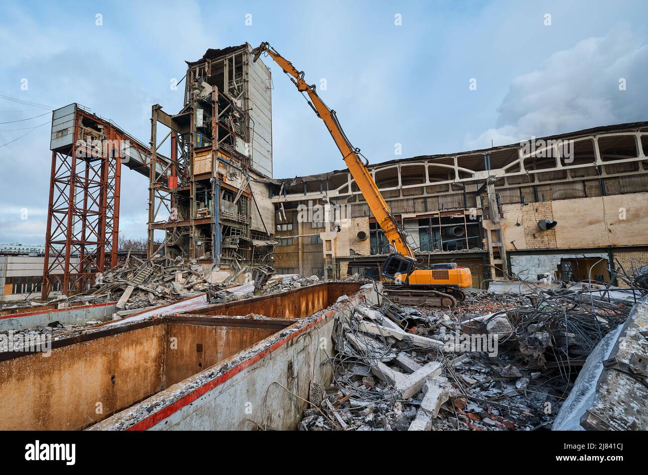Distruzione di vecchio edificio industriale da demolitore escavatore Foto Stock