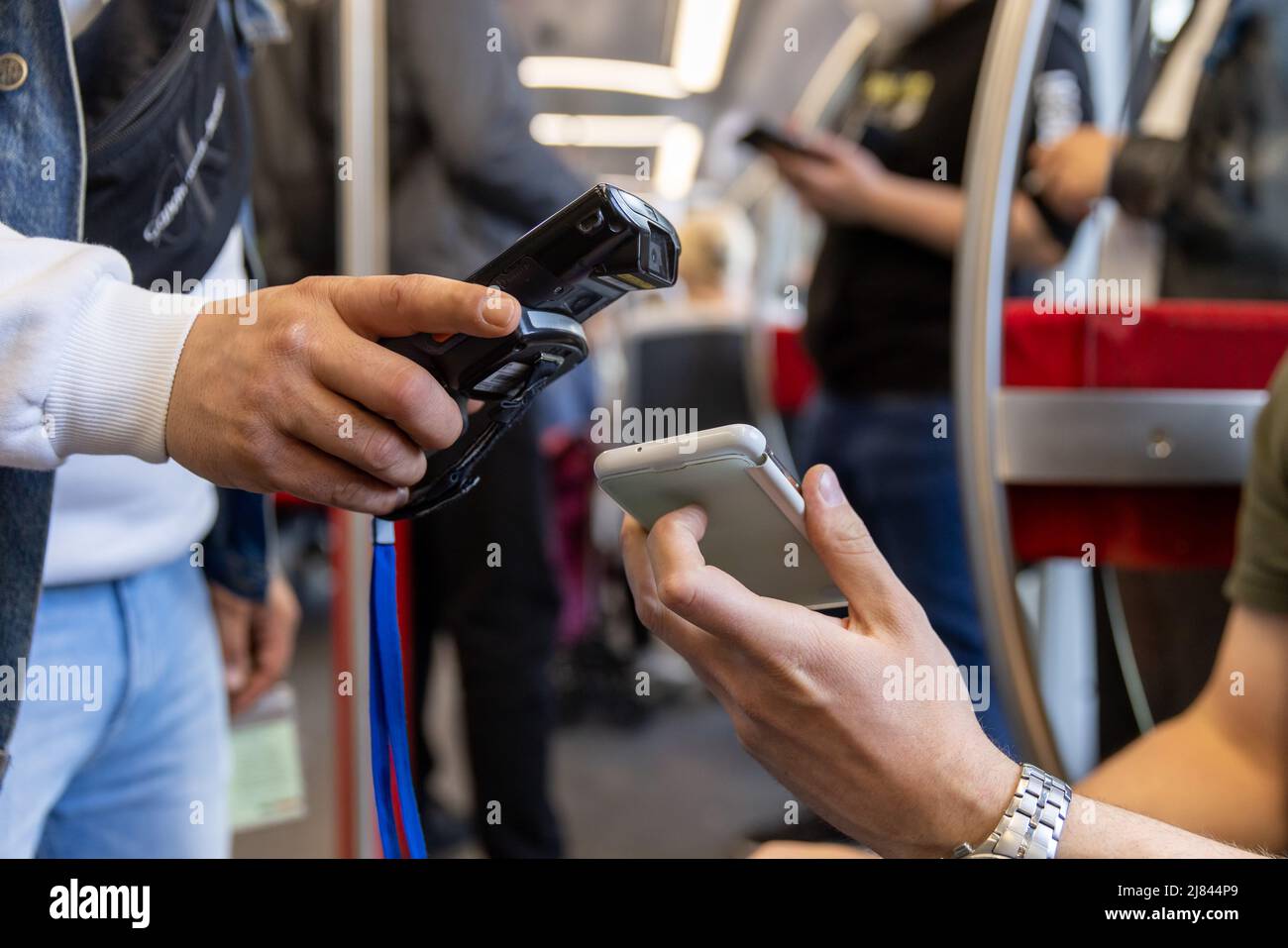 Norimberga, Germania. 05th maggio 2022. Un ispettore del biglietto (l) controlla il biglietto elettronico di un passeggero con un lettore elettronico nella metropolitana VAG (Verkehrs-Aktiengesellschaft Nürnberg). Credit: Daniel Karmann/dpa/Alamy Live News Foto Stock