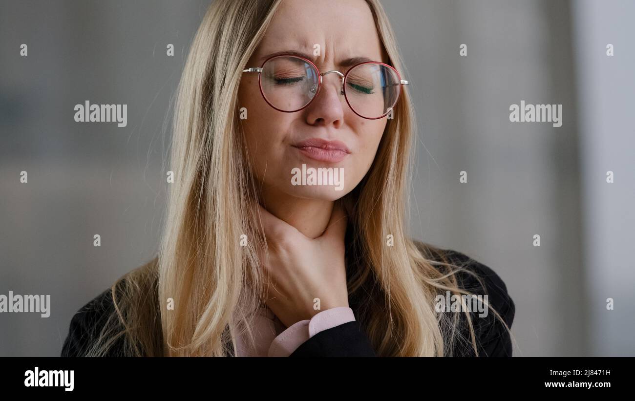 Donna di affari caucasica ragazza in occhiali direttore tenuta gola interna sente disagio mal di gola malattia respiratoria covid sintomo panico Foto Stock