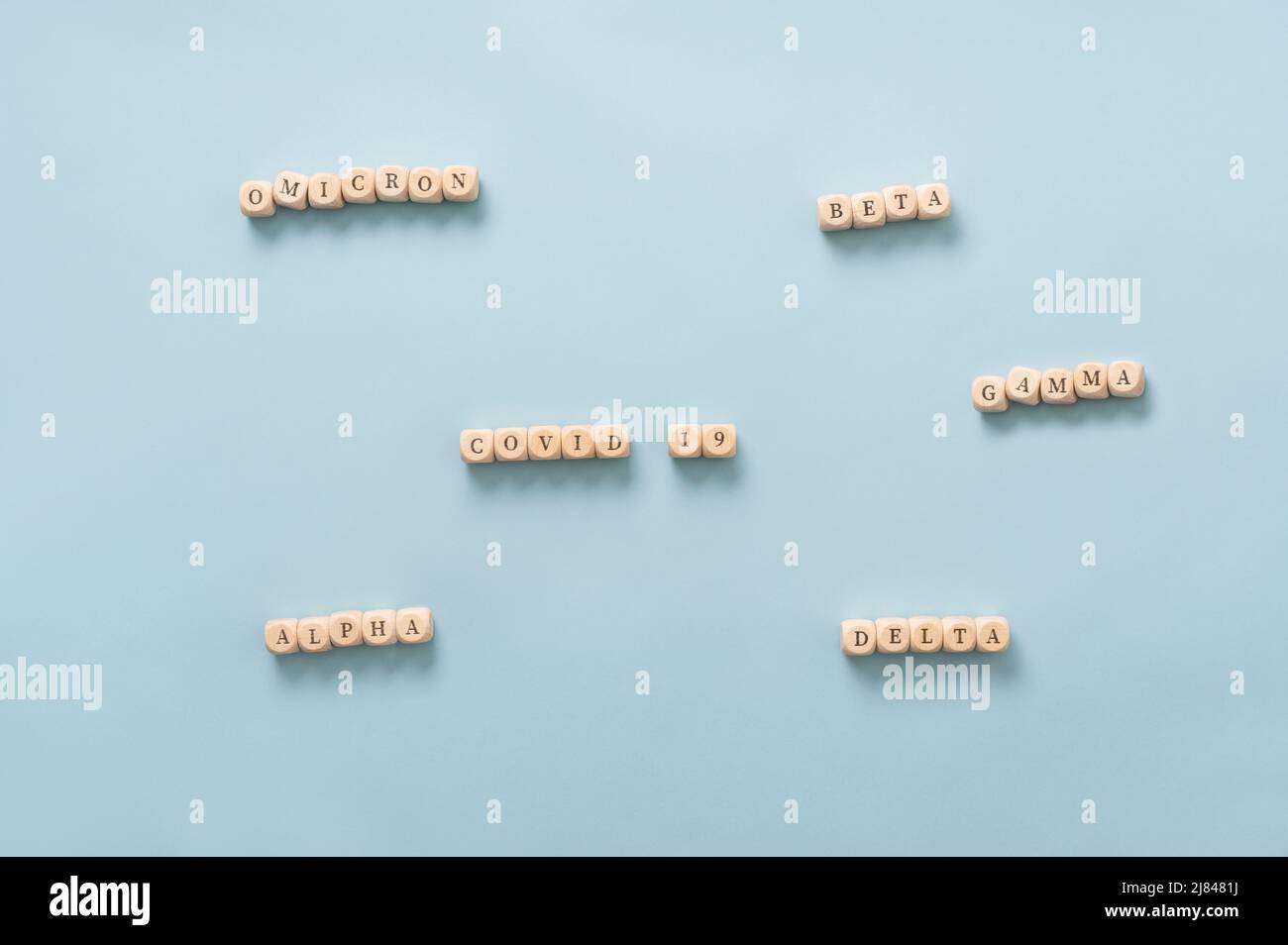 Immagine concettuale delle varianti di coronavirus - codice 19 e i suoi diversi nomi di mutazione scritti su dadi di legno su sfondo azzurro chiaro. Foto Stock