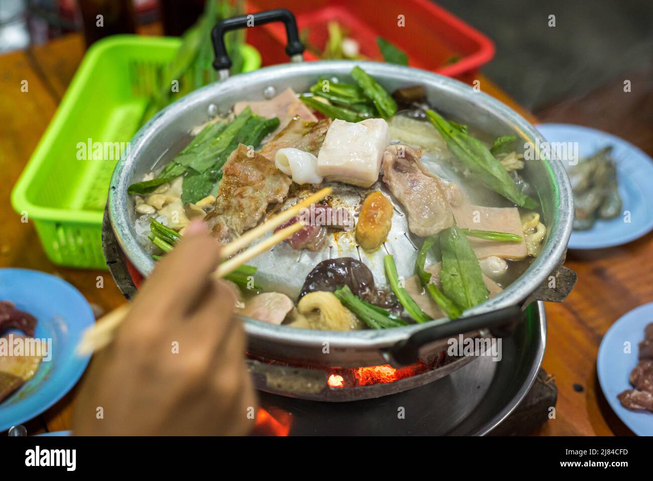 Carne, funghi e culantro assortiti (eryngium) cucinati su focaccine thailandesi (maw fai) in un ristorante self-service a Bangkok, Thailandia. Foto Stock