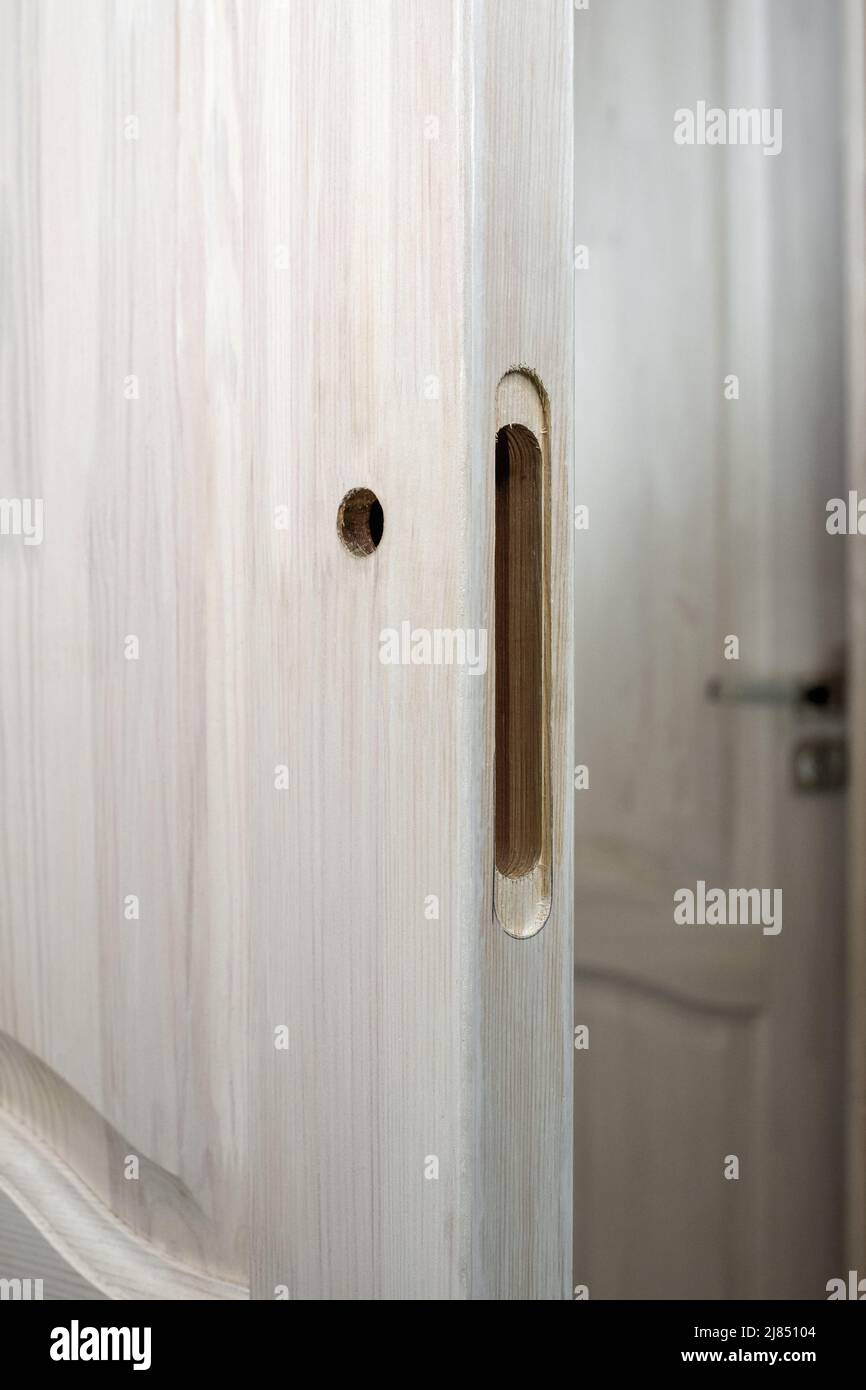 Installazione di una serratura su una porta di legno. Foro fresato e trapanato in una porta di legno, predisposto per l'installazione di una serratura. Foto Stock