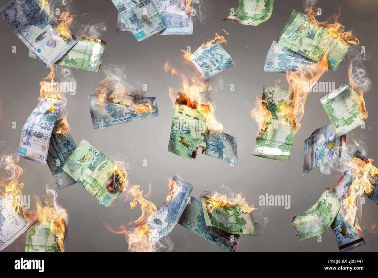 Bruciare le banconote di mange kazake che cadono Foto Stock