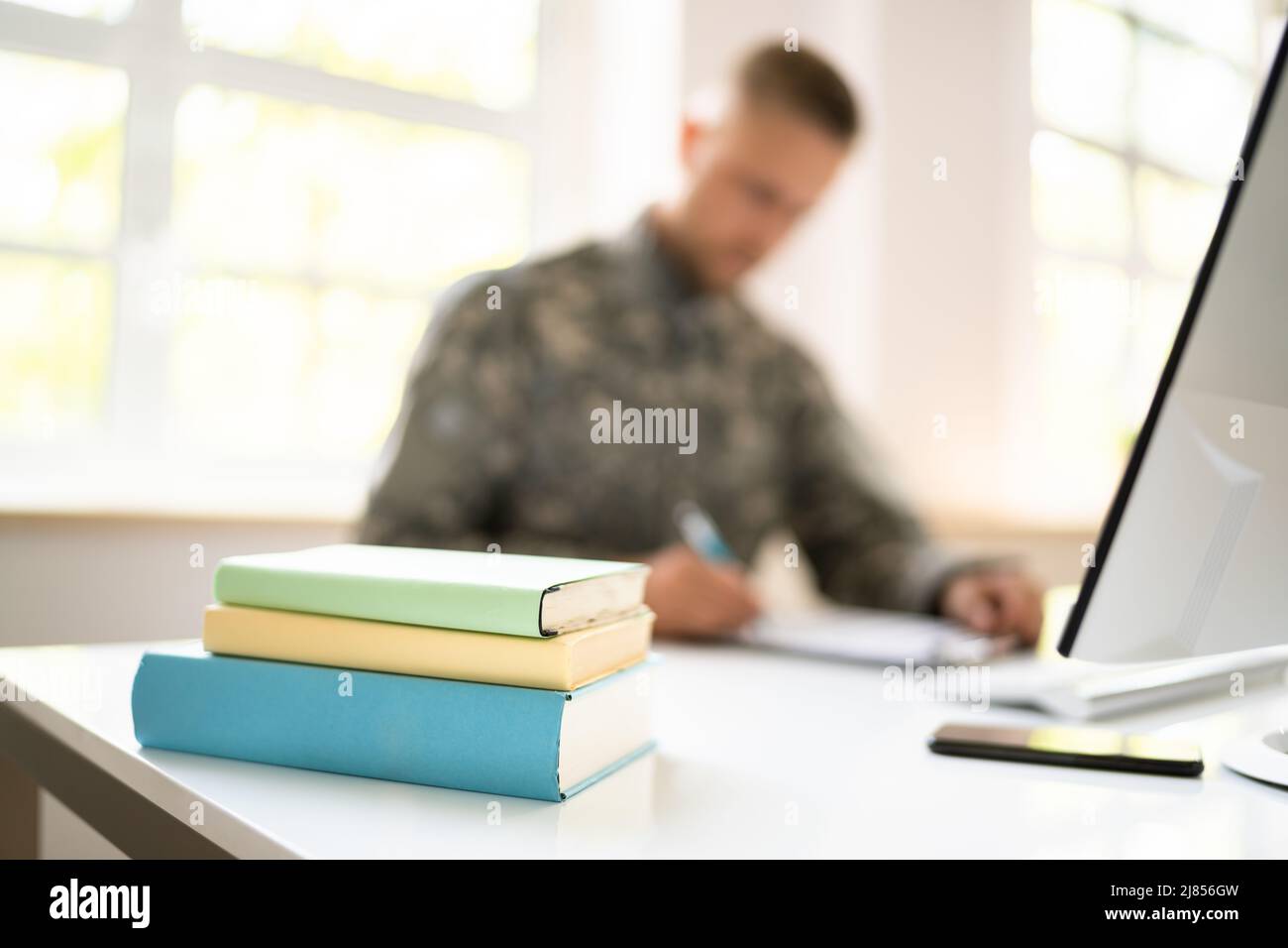 Educazione militare allo studente. Veterano soldato dell'esercito con il calcolatore Foto Stock