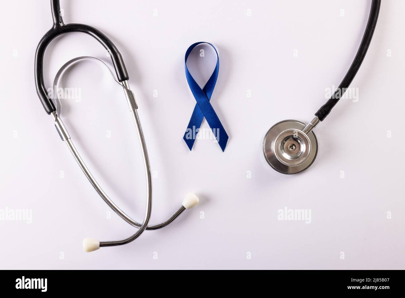Direttamente sopra il colpo del nastro blu di consapevolezza del cancro dello stomaco e dello stetoscopio su sfondo bianco Foto Stock