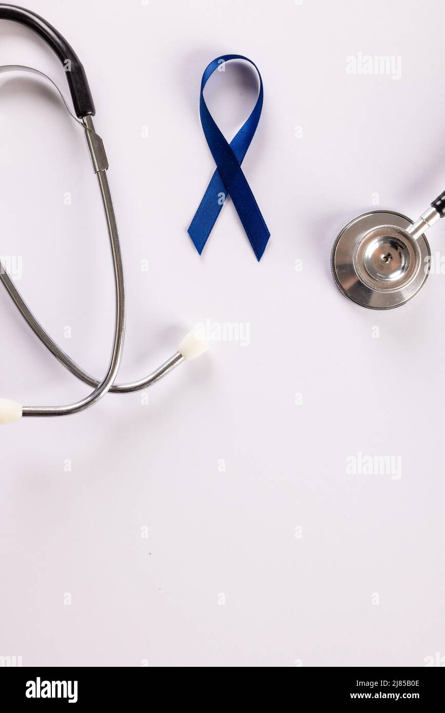 Direttamente sopra il colpo dello stetoscopio con nastro blu di consapevolezza del cancro dello stomaco su sfondo bianco Foto Stock