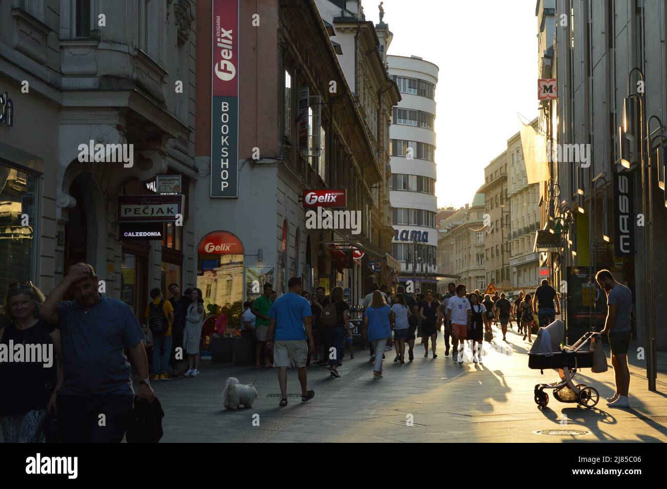 Persone che camminano lungo la strada nel pomeriggio Foto Stock