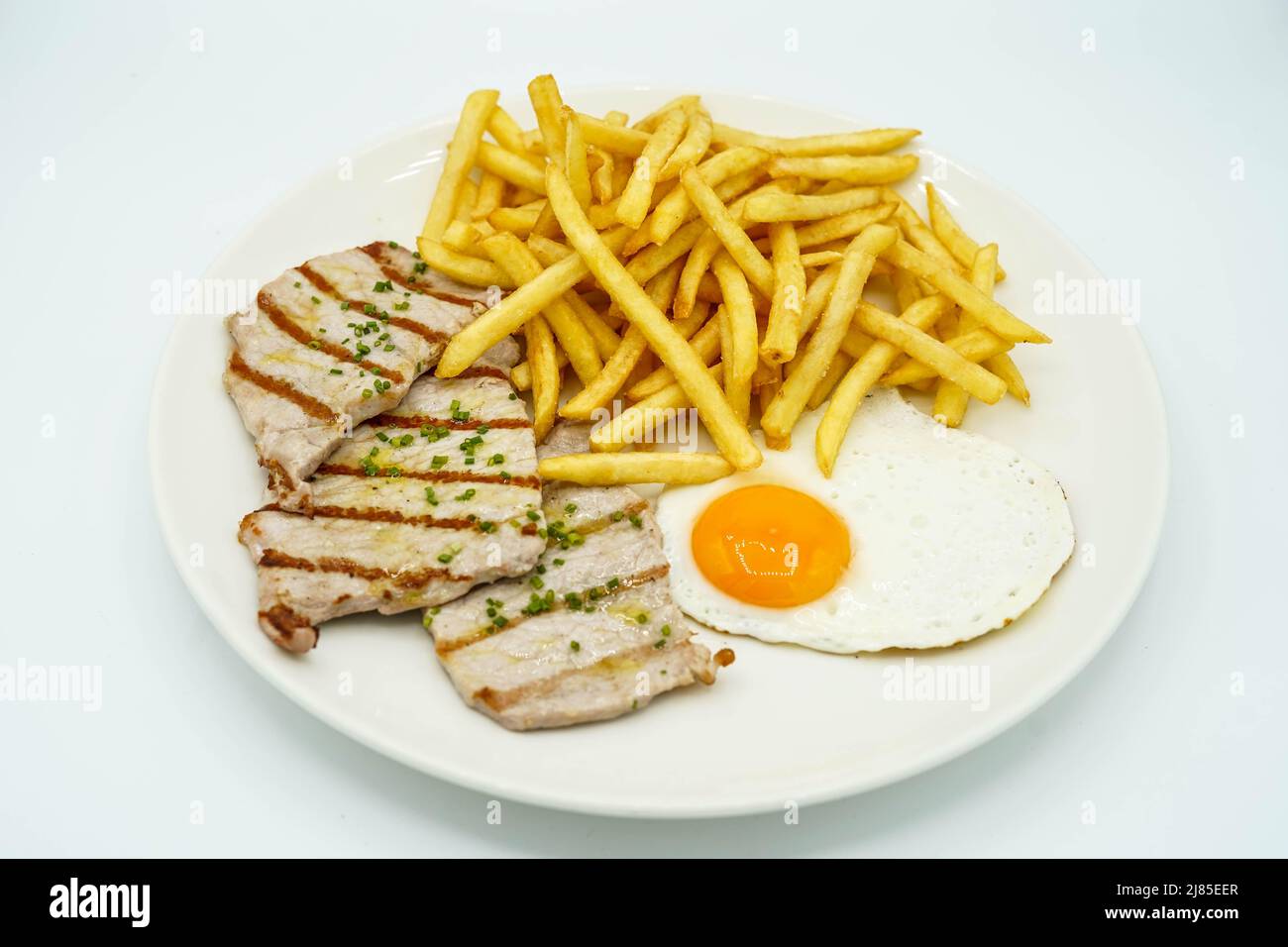 Piatto combinato di lombo di maiale con patate e uovo fritto Foto Stock