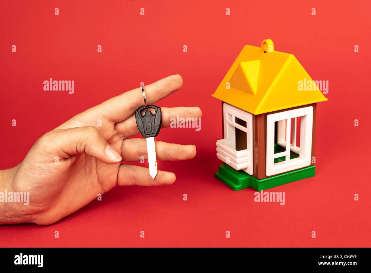 mano della donna che tiene la chiave alla casa, e un modello della casa Foto Stock