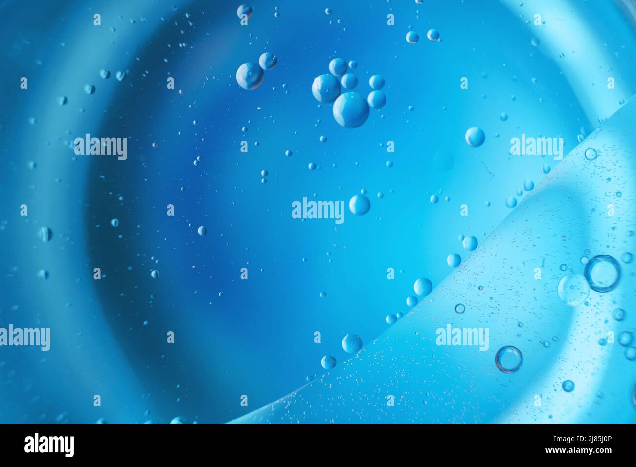 astratto sfondo azzurro con cerchi di olio . bolle d'acqua close up . bolle d'olio nella macro acqua. Foto Stock