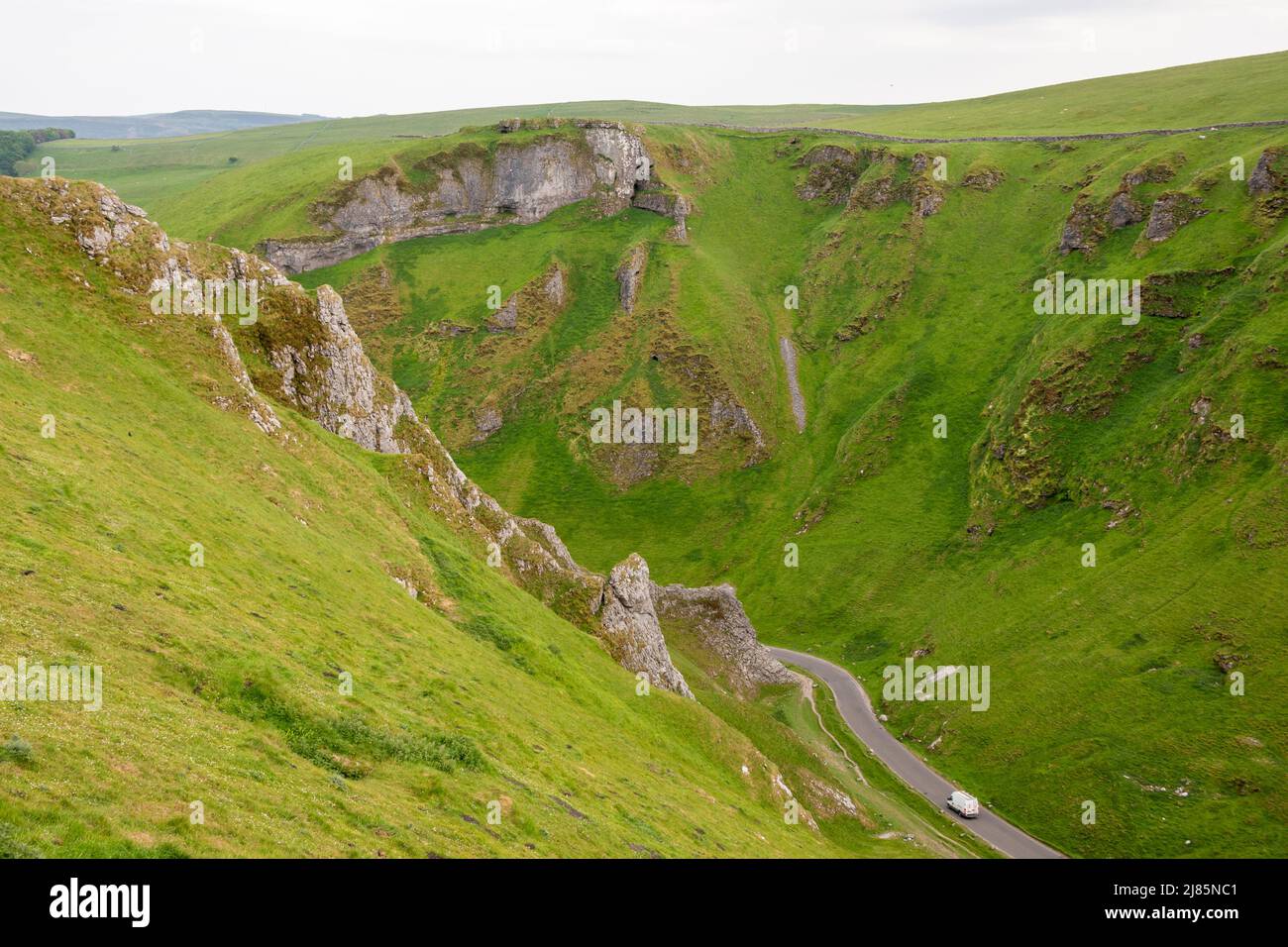 Derbyshire, Regno Unito – 5 aprile 2018: Le auto passano su una corsia tortuosa attraverso il Winnats Pass nel Peak District National Park Foto Stock