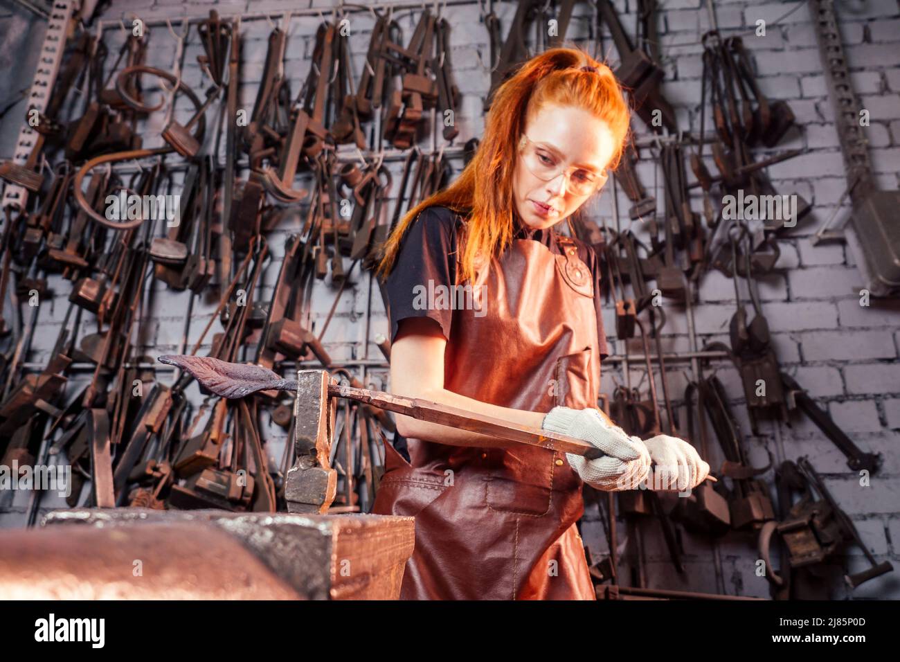 rosso zenzero donna fabbro ritratto in officina Foto Stock