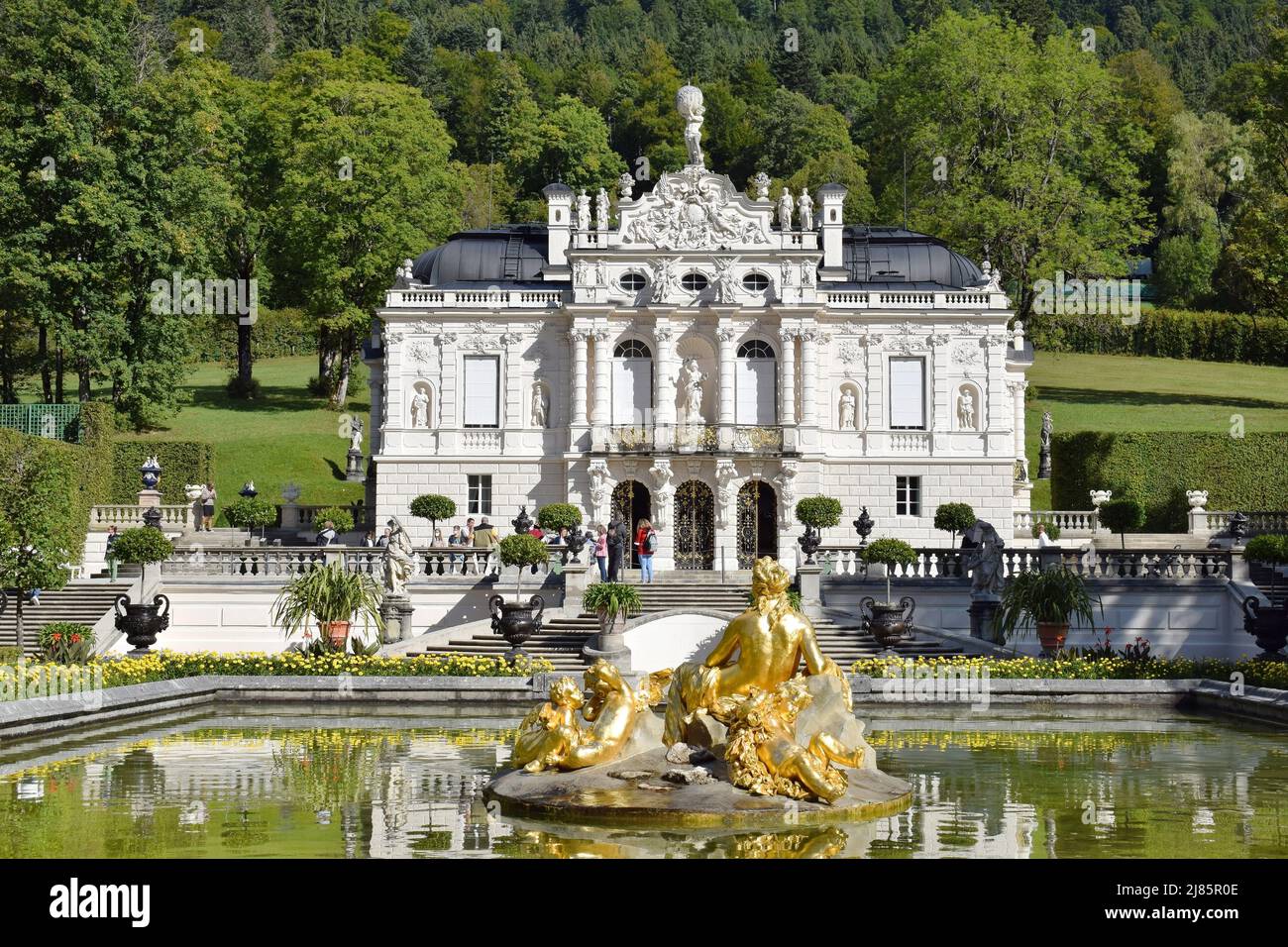 Vista sul Palazzo Linderhof (nella Baviera sud-occidentale vicino al villaggio Ettal) e una statua della Donna dorata e dei Bambini nel giardino del Palazzo Foto Stock