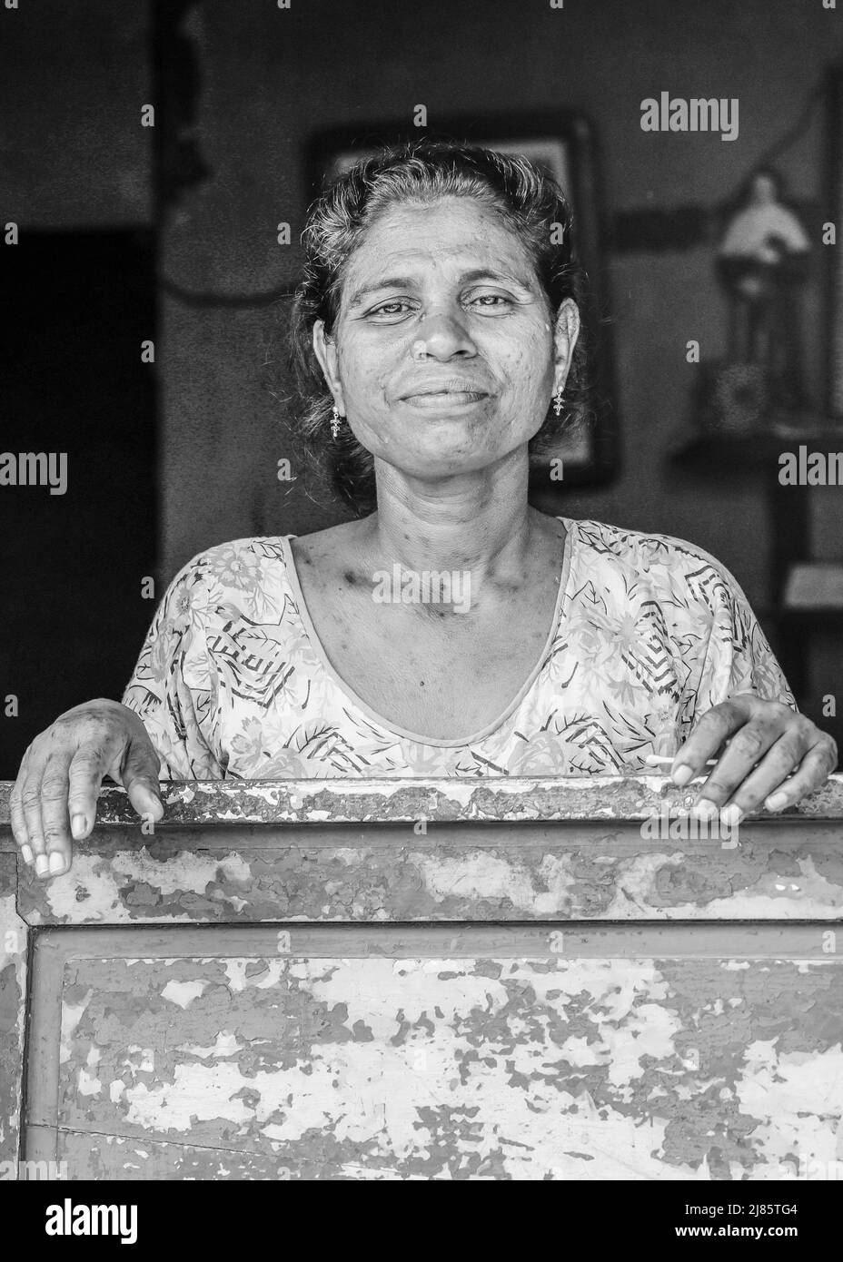 Ritratto di una donna locale in piedi nella porta della sua casa in Tangassery, Thangassery, Kerala, India. Foto Stock