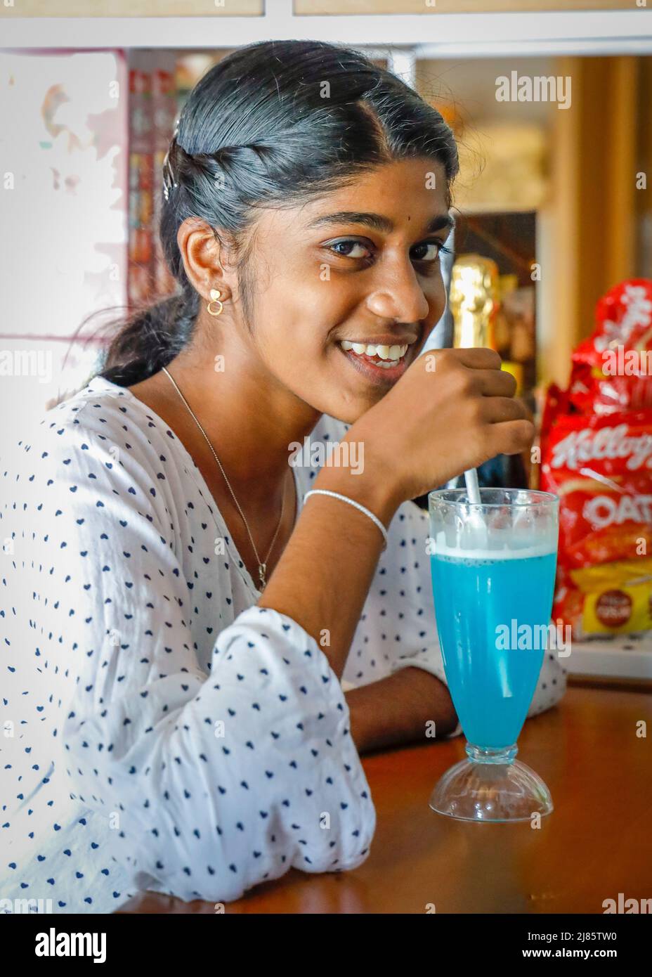 Ragazza adolescente indiana che beve softdrink di colore blu, Tangassery, Thangassery, Kerala, India. Foto Stock