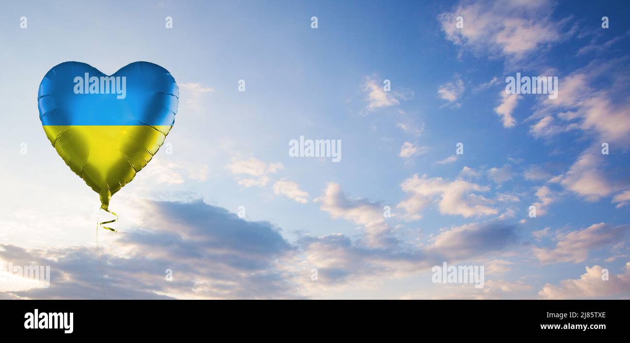 Palloncino blu e giallo sullo sfondo perfetto del cielo del giorno. Ucraina e concetto ucraino Foto Stock